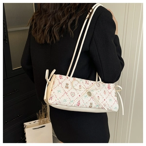 Detail of floral bear print bag with 3D bow and double shoulder straps on model