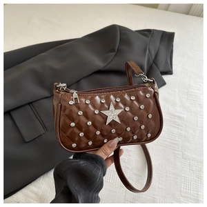 Close-up of dark brown quilted shoulder bag with large rhinestone star and shiny finish