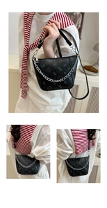 Detailed view of black textured leather bag with silver chain and bear pattern