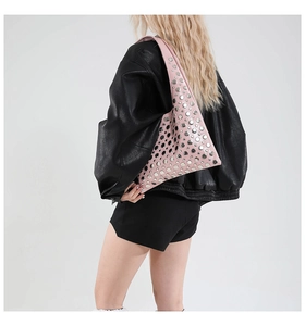 Detail of pink shoulder bag with silver round metal rivets and stylish faux leather texture