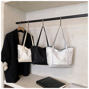 Detailed display of three stylish butterfly print tote bags in beige, black and silver