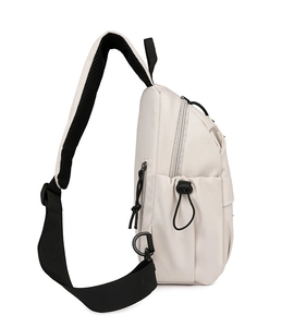 Detail view of cream sling bag featuring breathable mesh strap and side zipper pocket