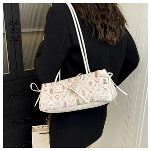 Detail of white shoulder bag with cute bow accents and floral animal print pattern