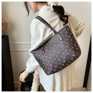 Detail of dark brown tote bag with pink bows and floral patterns for shoulder wear