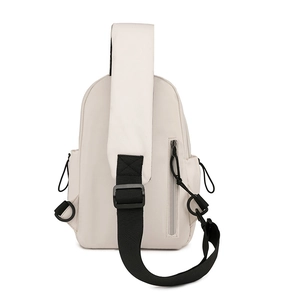 Detail view of cream canvas chest bag featuring side drawstring pockets and black strap