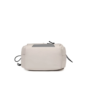 Close-up of minimalist cream utility bag with black zipper and drawstring detail