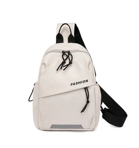 Detailed view of the gray reflective safety strip on a cream nylon crossbody bag