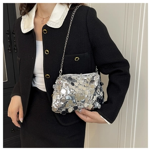 Close-up of silver sequin bag surface with reflective round discs and metal chain strap