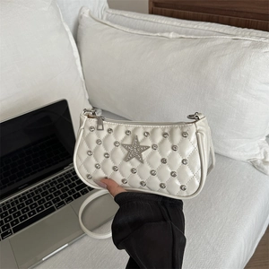 White quilted shoulder bag with large rhinestone star on a minimalist lifestyle setting