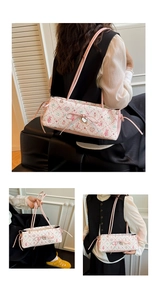 Detail of pink floral jacquard fabric with bow and heart pendant on shoulder bag