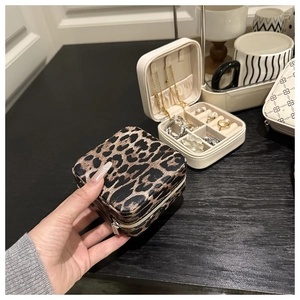 Detaillierte Nahaufnahme einer kleinen Schmuckschatulle mit Leopardenmuster in der Hand