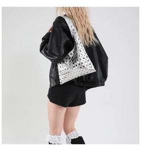 Detail of silver studded bucket bag with metallic rivets and shiny faux leather finish