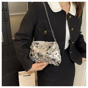 Detail view of a silver sequin crossbody bag with chain strap shown in a lifestyle setting
