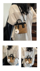 Retro tan bucket bag with black trim and plush monster charm shown on a model
