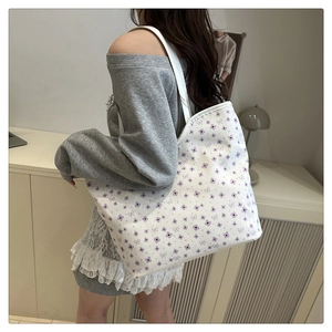 Detail of floral tote bag with lavender print and bow patterns shown on shoulder