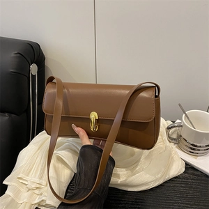Classic brown leather baguette shoulder bag with elegant gold metal buckle and long strap