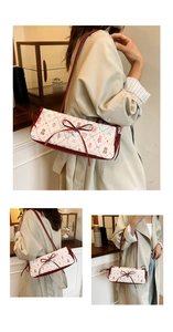 Detail of white embossed fabric with cartoon bear print and red leather bow on bag