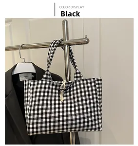 Detail of checkered canvas bag with beige rope closure and black toggle on a hanger