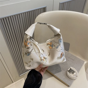 Cream embroidered handbag with floral bird motifs and adjustable shoulder strap