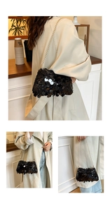 Detailed view of shimmering black sequins and gold chain strap on a stylish handbag