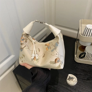 Embroidered silk handbag with floral bird patterns and elegant white tassel detail