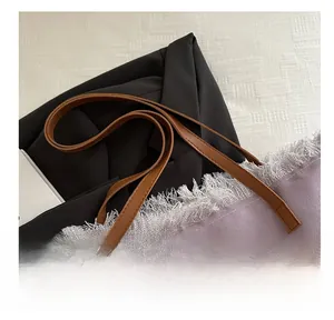 Close-up of purple canvas tote bag featuring white fringe trim and brown leather handles
