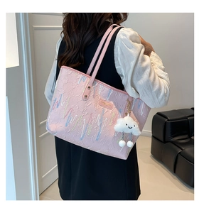 Close-up detail of pink textured tote bag featuring rainbow embroidery and cloud pendant