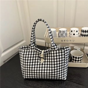 Minimalist black and white gingham tote bag with wooden button closure and canvas texture