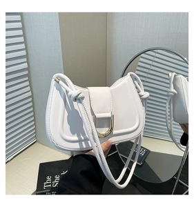 Close-up of white crescent saddle bag with gold D-buckle and knotted shoulder strap