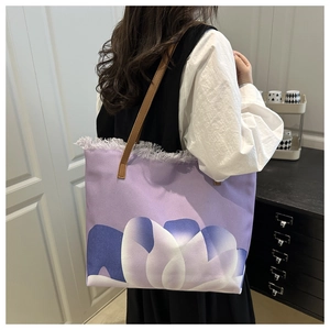 Vista detallada del bolso tote con estampados florales morados y adornos de flecos