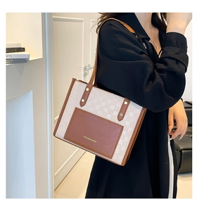Détail du sac cabas à damier avec poche en cuir marron et lettrage doré sur le devant