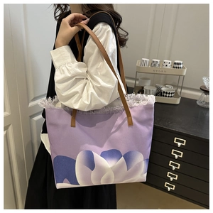 Détail du sac cabas en toile avec motif lotus, franges blanches et anses en cuir