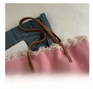 Détail du cabas en toile rose avec bords effilochés, anses en cuir et lettrage Summer