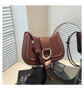 Brown crescent saddle bag with golden horseshoe clasp and knot shoulder strap detail