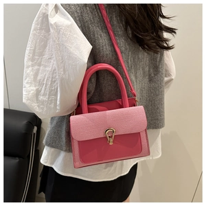 Close-up of pink leather crossbody bag with golden U-shaped buckle on a model