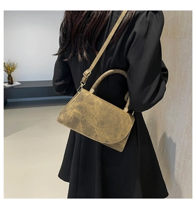 Modern olive green vintage texture crossbody bag shown styled with a black dress