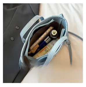 Internal view of light blue bucket bag showing storage space for phone and cosmetics