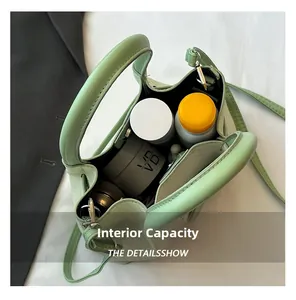 Macro shot of light green bucket bag showing spacious interior with skincare bottles