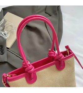 Gros plan du sac seau tressé avec poignées en cuir rose et détails de nœuds élégants