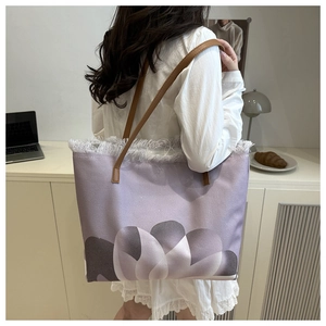 Dettaglio della borsa tote in tela lavanda con bordi sfrangiati e tracolla in pelle