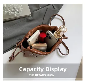 Interior view of brown pleated bucket bag showing capacity for phone and cosmetics