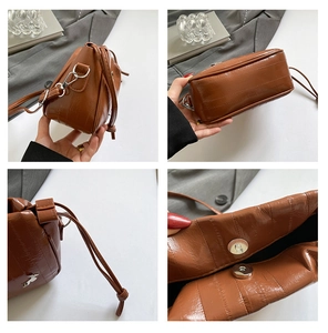 Detail view of brown pleated cloud bag featuring silver rabbit charm and textured PU leather