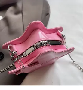 Detail of silver zipper closure and metallic finish on pink star-shaped crossbody bag