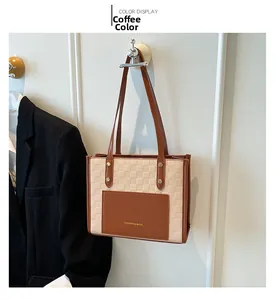 Détail du sac cabas à damier marron et crème avec inscription dorée élégante