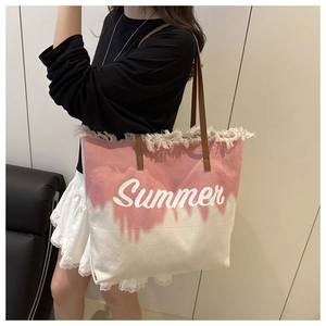 Détail d'un grand sac cabas en toile dégradé rose avec imprimé Summer et bords effilochés