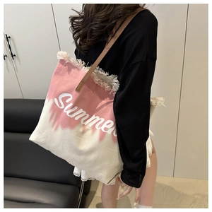 Détail du sac cabas en toile tie-dye rose avec imprimé Summer et bandoulière en cuir brun