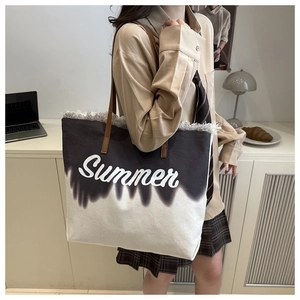 Détail du grand sac de plage en toile avec dégradé noir et blanc et bords effilochés