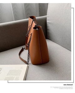Detail view of brown faux leather tote with gunmetal chain and adjustable shoulder strap