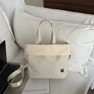 Borsa tote in tela color crema minimalista con tracolla e design con texture a pieghe
