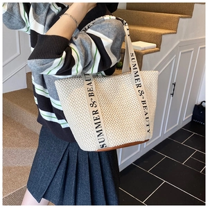 Détail d'un sac cabas en paille tissée avec sangles imprimées et base en cuir